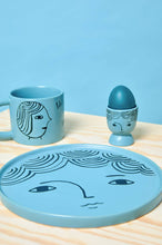 Tasse mit Gesichtern in Türkis